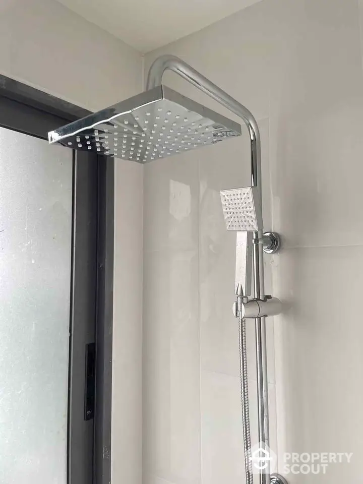 Modern bathroom shower with sleek chrome fixtures and frosted glass window