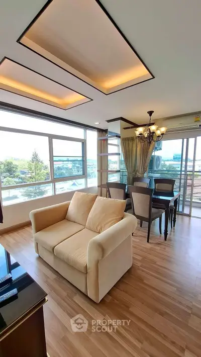 Spacious living room with modern decor and large windows offering a scenic view, perfect for relaxation.
