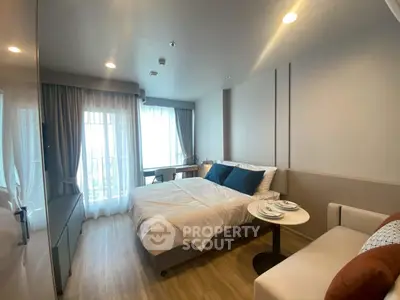 Modern bedroom with cozy decor and natural light, featuring a comfortable bed and stylish furnishings.
