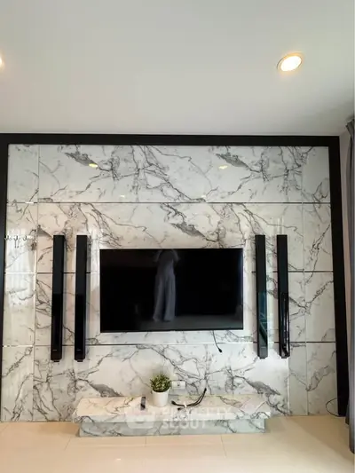 Luxurious living room with marble accent wall and modern TV setup.