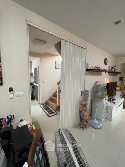 Spacious living area with modern decor and staircase, ideal for family living.