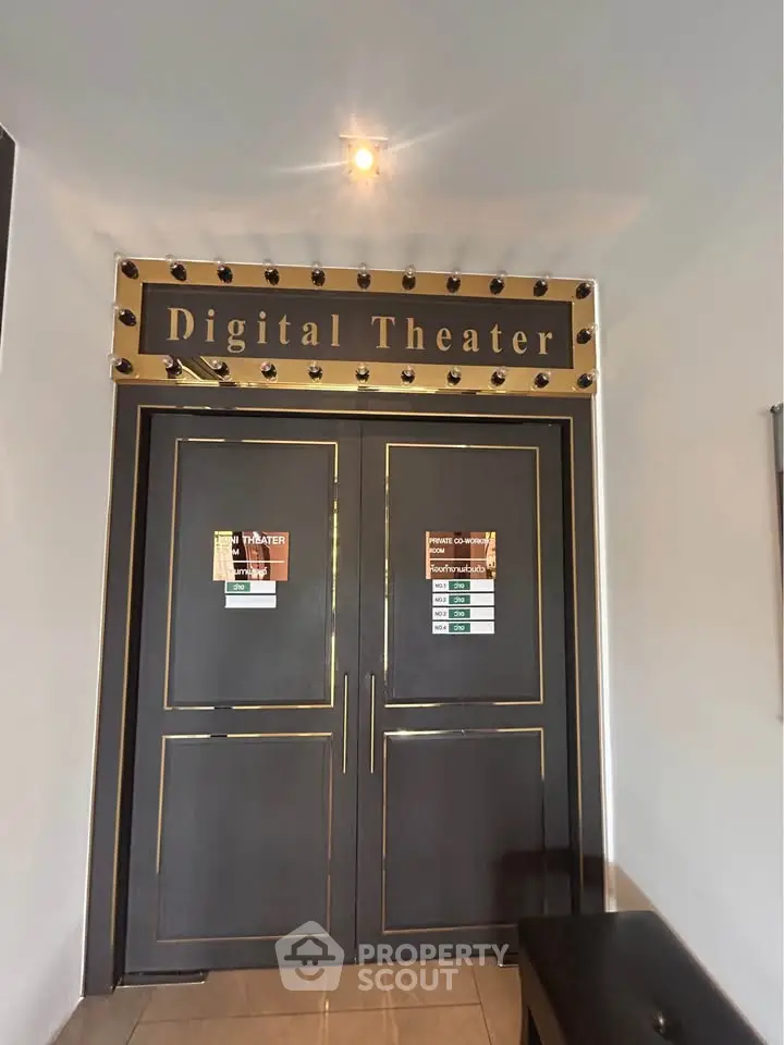 Elegant digital theater entrance with stylish double doors and illuminated sign.