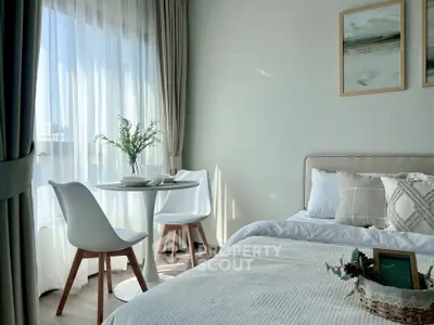 Bright and cozy bedroom with modern decor and natural light, featuring a small dining area by the window.