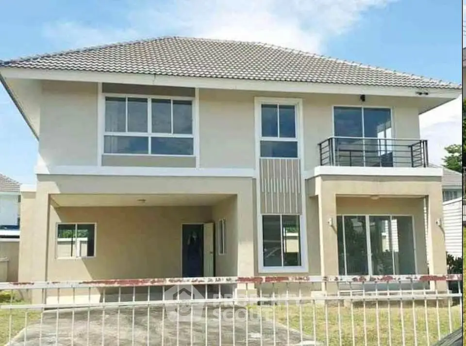 Modern two-story house with large windows and a small balcony, perfect for family living.