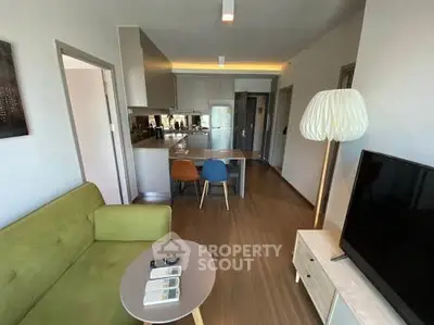 Modern living room with open kitchen, stylish furniture, and cozy ambiance.