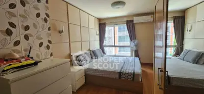 Spacious bedroom with modern decor and large window for natural light