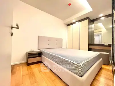 Modern bedroom with stylish furniture and wooden flooring in a cozy apartment.