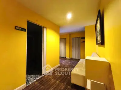 Bright yellow hallway with modern decor and wooden flooring in a stylish property.