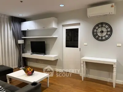 Modern living room with wall-mounted TV, air conditioning, and stylish decor