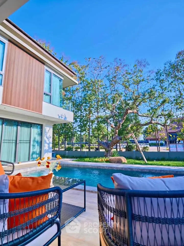 Luxurious modern home with poolside view and stylish outdoor seating.