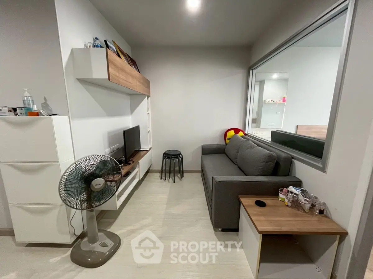 Modern living room with sleek furniture and neutral tones, featuring a cozy sofa and stylish decor.