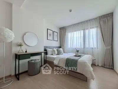 Modern bedroom with stylish decor and natural light, featuring a cozy bed and elegant furnishings.