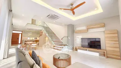 Spacious modern living room with open layout, stylish furniture, and elegant staircase in a luxury home.