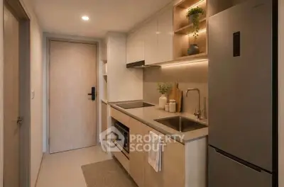 Modern compact kitchen with sleek cabinetry and stainless steel appliances in cozy apartment.