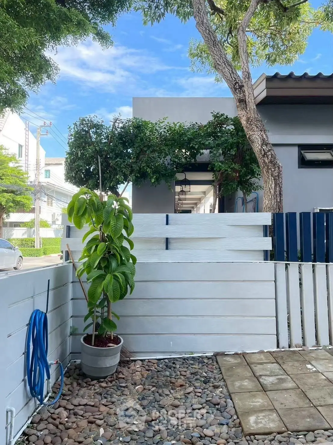 Charming modern home exterior with lush greenery and stylish fence