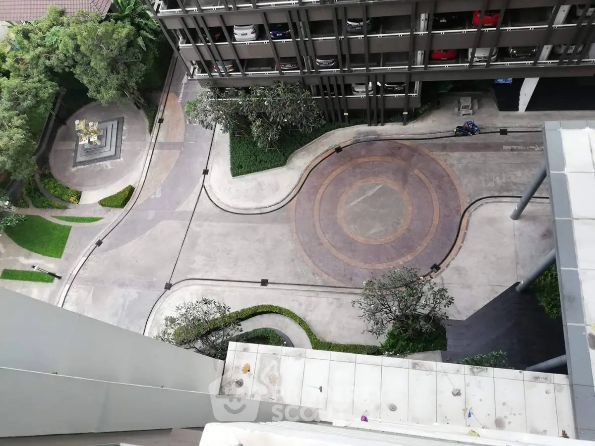 Stunning aerial view of modern building exterior with landscaped pathways and lush greenery.