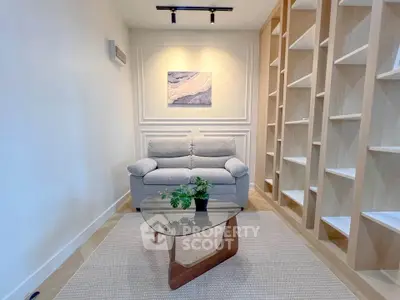 Modern living room with stylish sofa, glass coffee table, and built-in shelving for a chic, minimalist look.