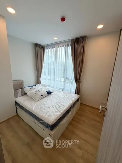 Cozy bedroom with large window and modern decor in a stylish apartment.