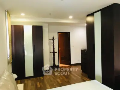 Spacious bedroom with modern wardrobes and wooden flooring