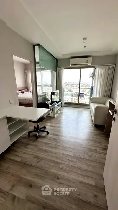 Modern living room with city view, featuring sleek furniture and large windows for natural light.