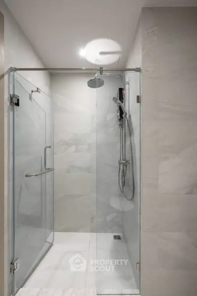 Modern bathroom with sleek glass shower enclosure and rainfall showerhead.