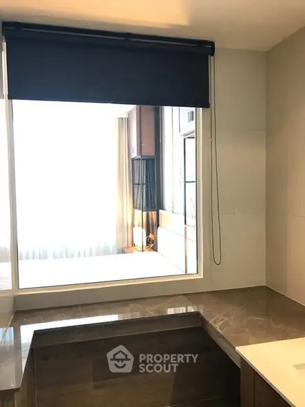 Modern bathroom with large window and elegant marble surfaces