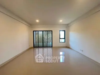 Spacious empty living room with modern sliding doors and glossy tiled flooring.