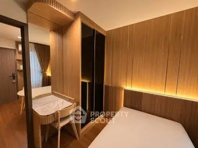Modern bedroom with wooden paneling and ambient lighting, featuring a cozy bed and stylish desk area.