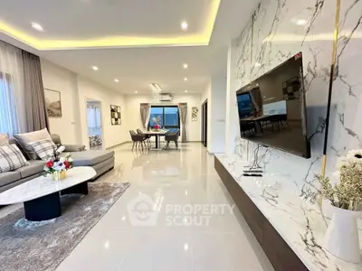 Luxurious modern living room with marble accents and open dining area.