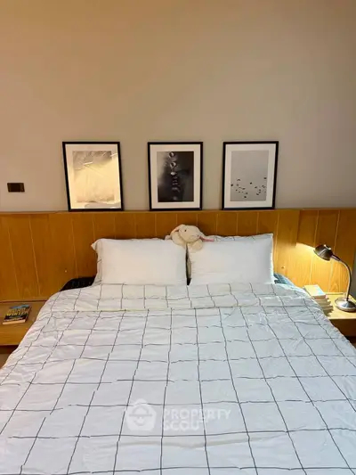 Cozy bedroom with modern decor and stylish artwork above the bed, perfect for relaxation.