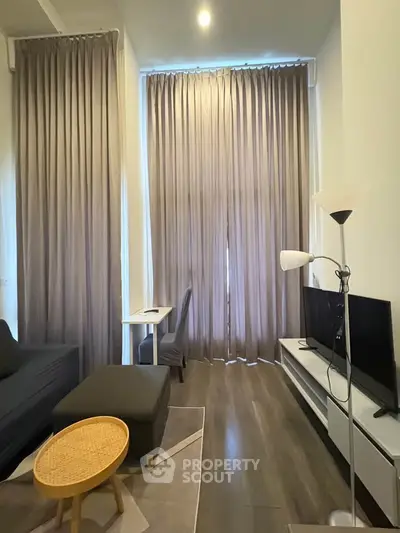 Modern living room with tall curtains, sleek furniture, and cozy lighting