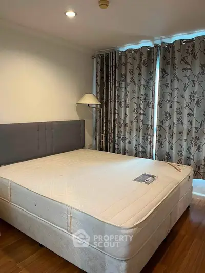 Spacious bedroom with elegant curtains and cozy lighting, perfect for relaxation.