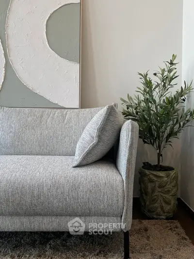 Stylish modern living room with elegant gray sofa and decorative plant
