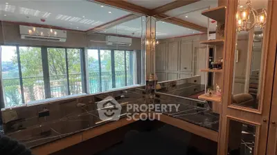 Luxurious study room with elegant wood paneling and large windows offering scenic views.