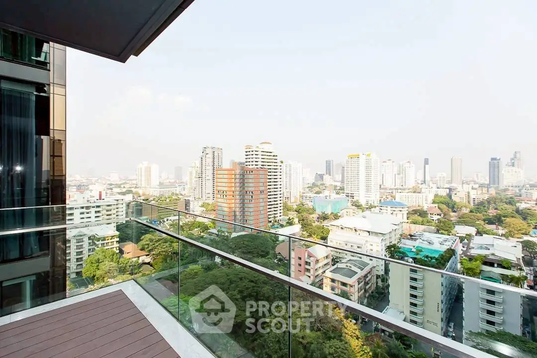 Stunning cityscape view from a modern balcony with glass railing, perfect for urban living.