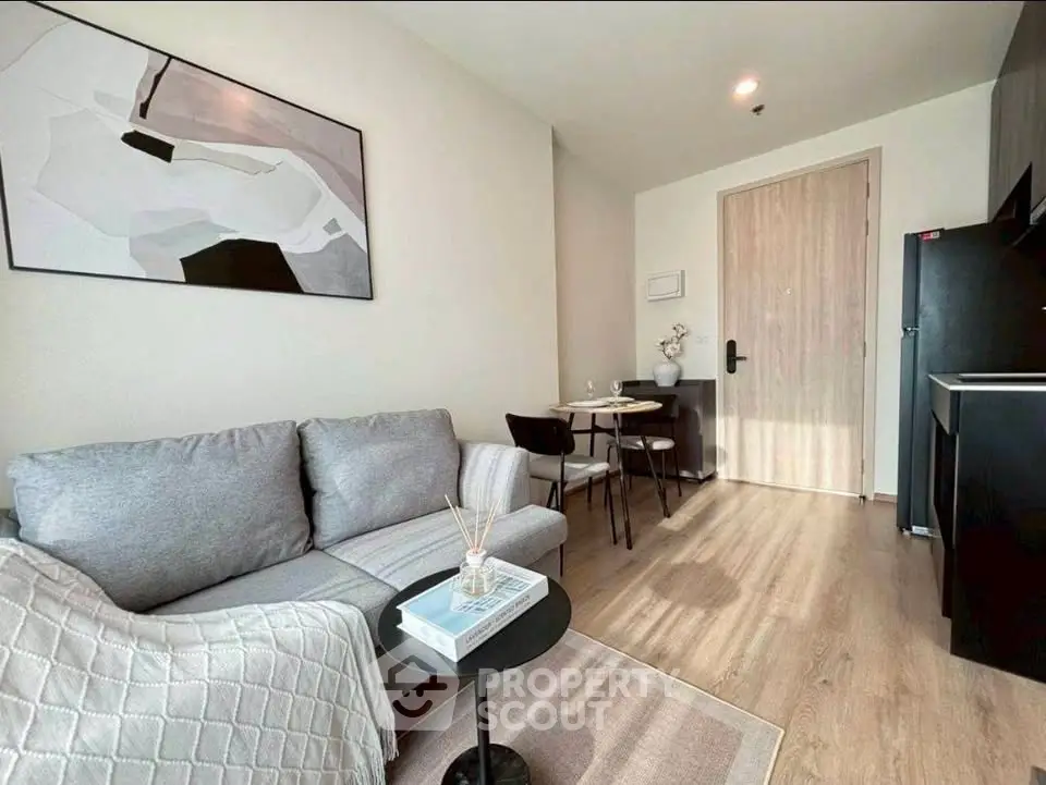 Modern living room with cozy gray sofa, stylish decor, and compact dining area in a chic apartment.
