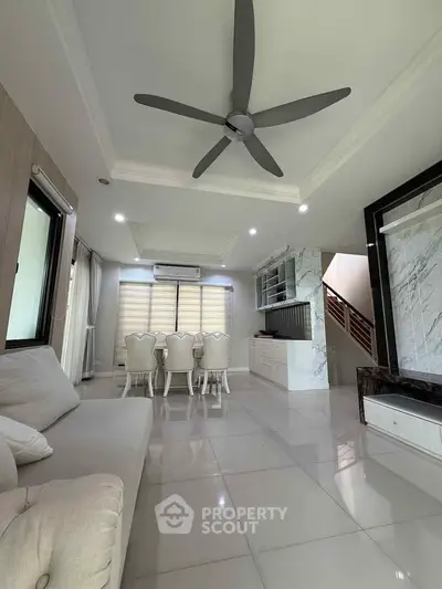 Spacious modern living room with elegant dining area and ceiling fan