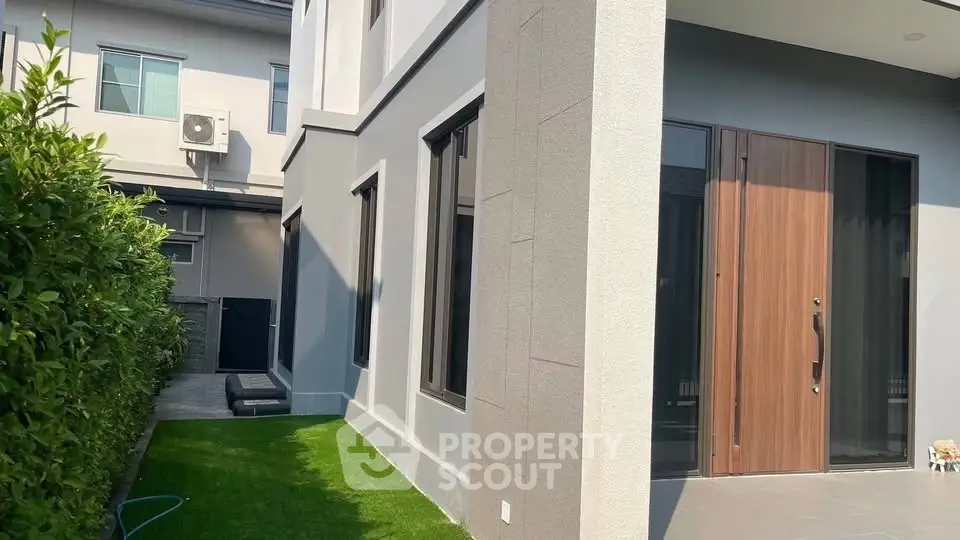 Modern home exterior with lush garden and sleek entrance