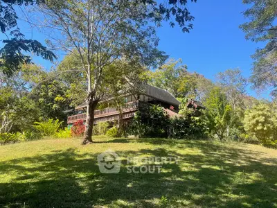Charming hillside home surrounded by lush greenery and trees, offering serene natural views.