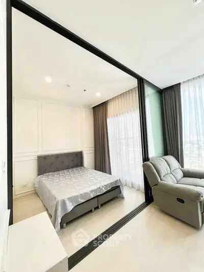 Modern bedroom with large windows and cozy recliner in a stylish apartment