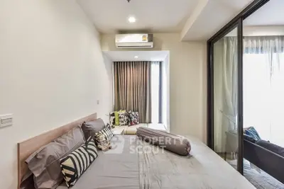 Modern bedroom with cozy decor and balcony access in a stylish apartment.