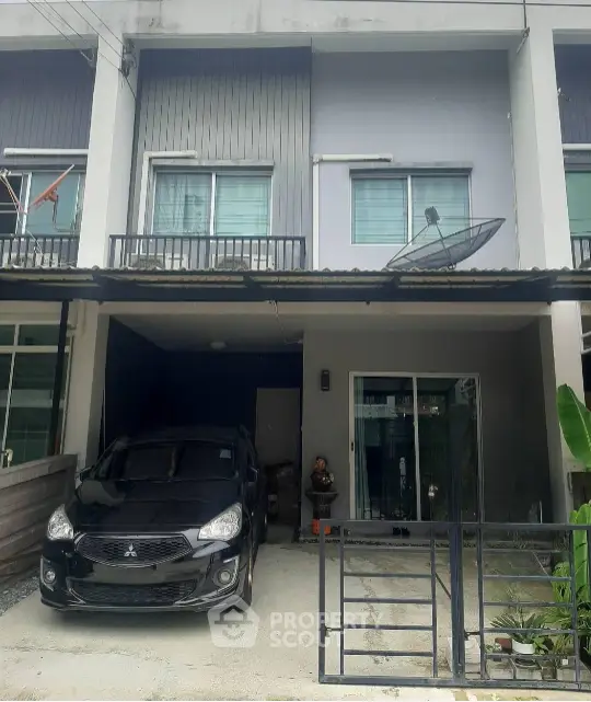 Modern townhouse with carport and satellite dish in urban setting