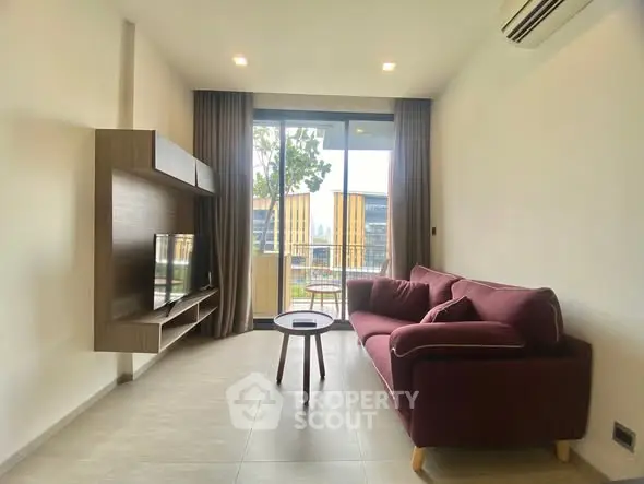 Modern living room with stylish furniture and balcony view in a contemporary apartment.