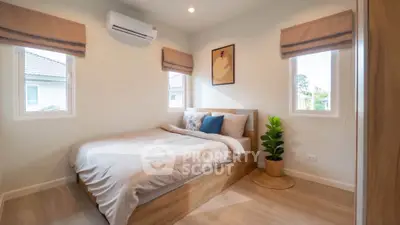 Cozy bedroom with natural light and modern decor in a stylish home.