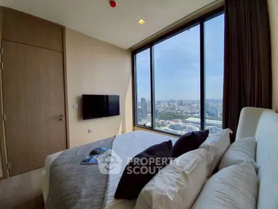 Luxurious bedroom with stunning city view from floor-to-ceiling windows, modern decor and wall-mounted TV.
