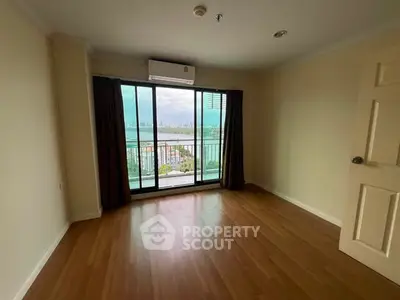 Spacious room with wooden flooring and balcony offering stunning city view