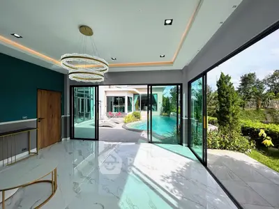 Luxurious living room with pool view and modern lighting in a contemporary home.