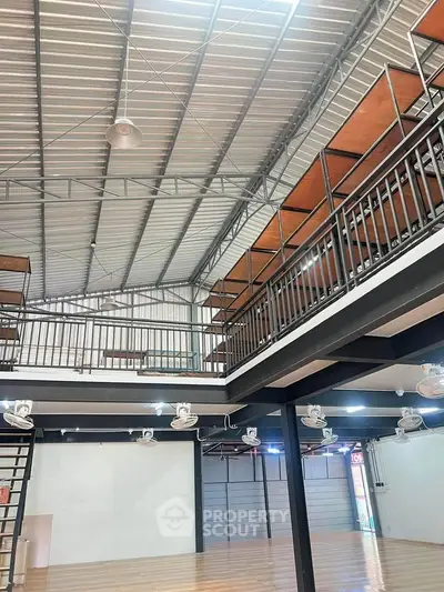 Spacious industrial-style loft with high ceilings and mezzanine level, perfect for creative workspace or modern living.