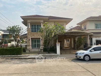 Charming two-story suburban house with lush greenery and spacious driveway in a serene neighborhood.