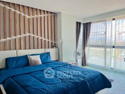 Spacious bedroom with modern decor and large windows offering stunning views.